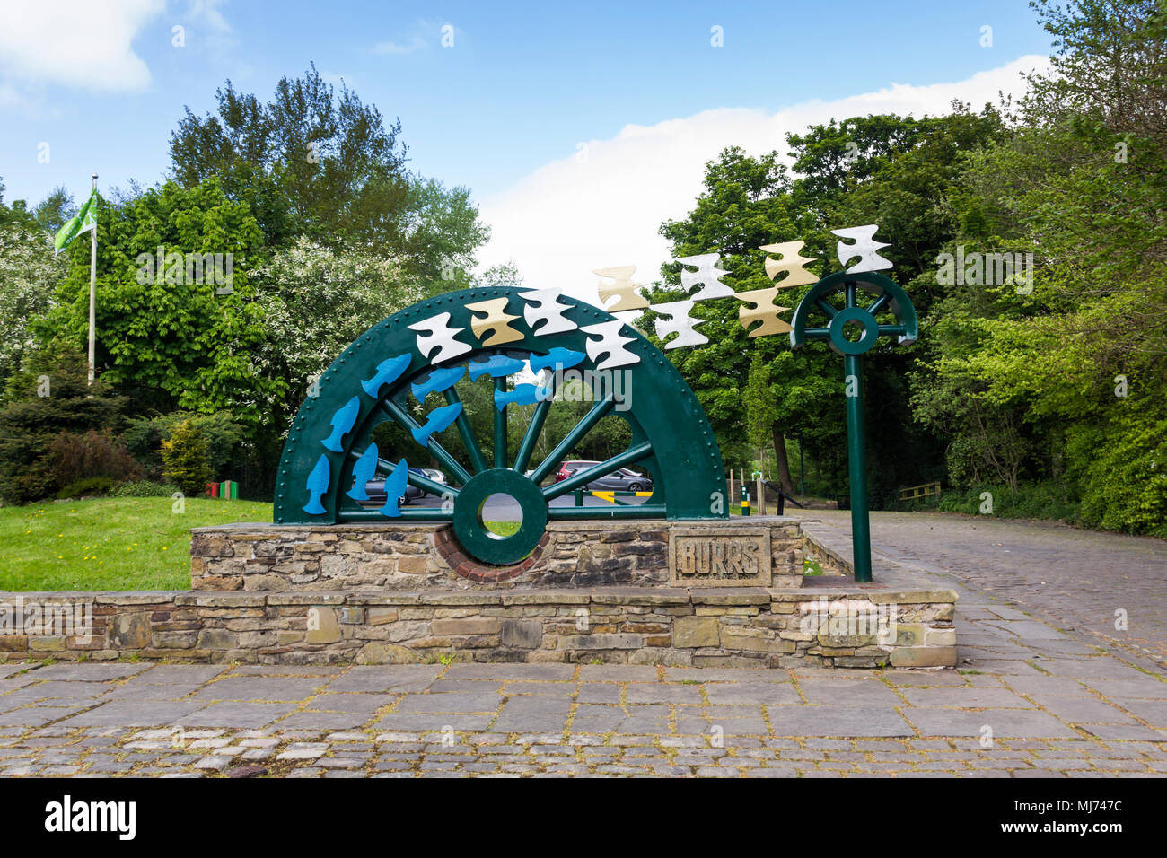 Waterwheel sculpture by David Kemp at the entrance to Burrs Country Park, Bury, installed in 1996. The Waterwheel was commissioned by Bury Council. Stock Photo