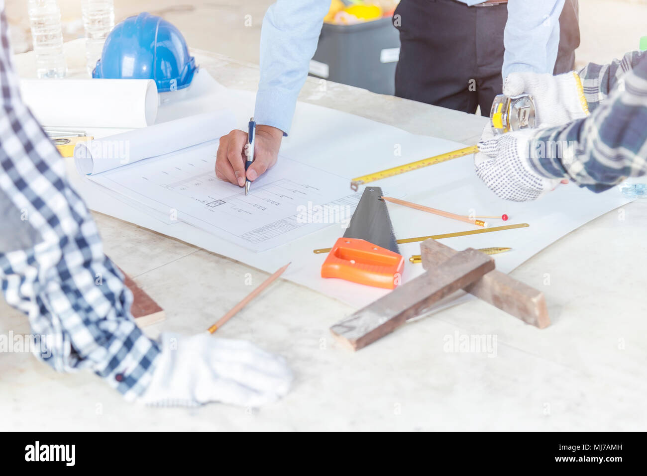 Civil engineer and foreman meeting and working on blueprint. Architects workplace, architectural project blueprints ruler calculator. Stock Photo