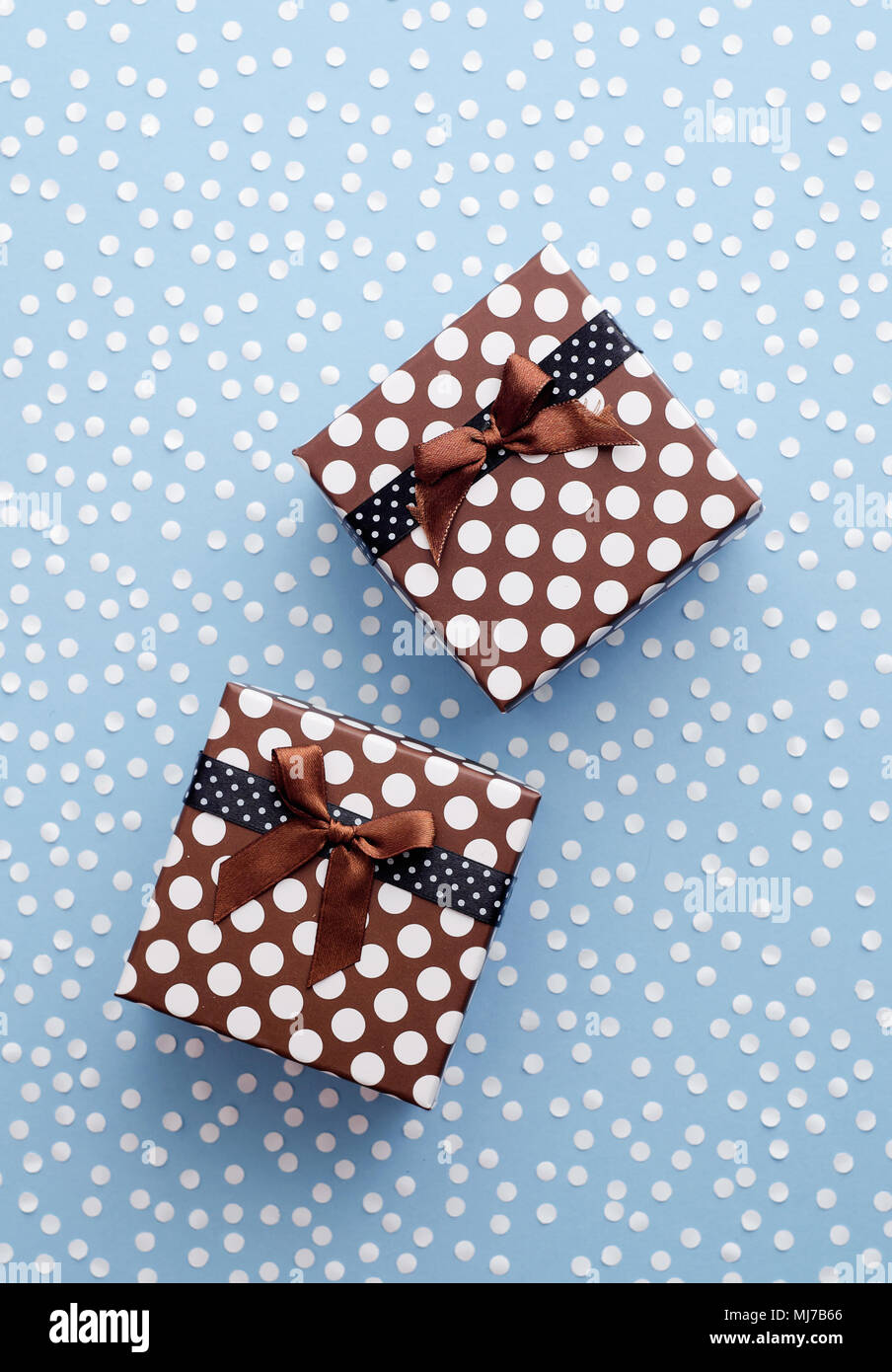 Christmas Gift Boxes with snow confetti over blue background, above view Stock Photo