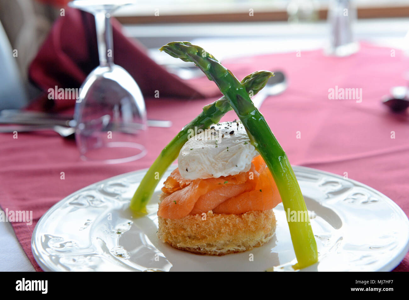 Salmon dish with egg and asparagus on a table in a restaurant Stock Photo