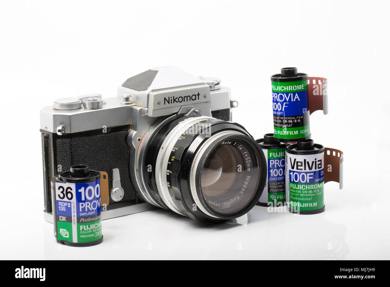 A Nikomat FTN film camera made by Nikon fitted with a Nikkor-S 50mm 1.4 lens. Dorset England UK. It is pictured with a selection of Fuji film cainster Stock Photo