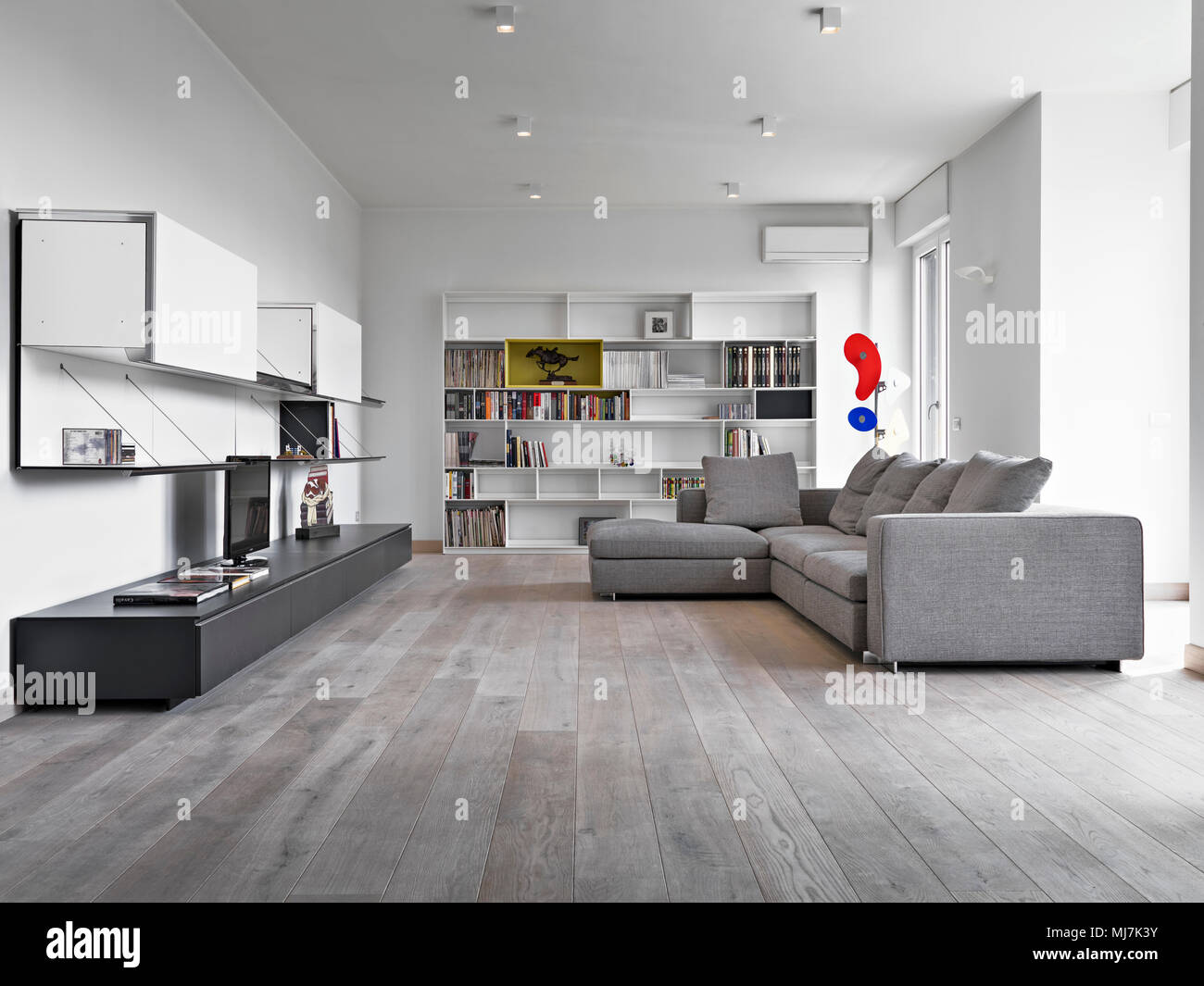 interiors shots of a modern living room with gray fabric sofa and wooden floor Stock Photo
