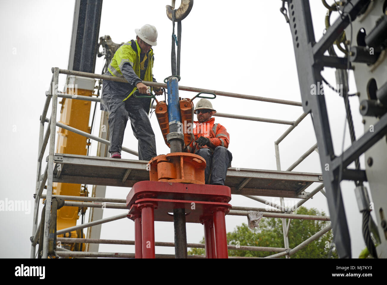 MOANA, NEW ZEALAND, NOVEMBER 4, 2017: Engineers work in the rain setting up lifting equipment to remove the steel casing from an oil well that is bein Stock Photo