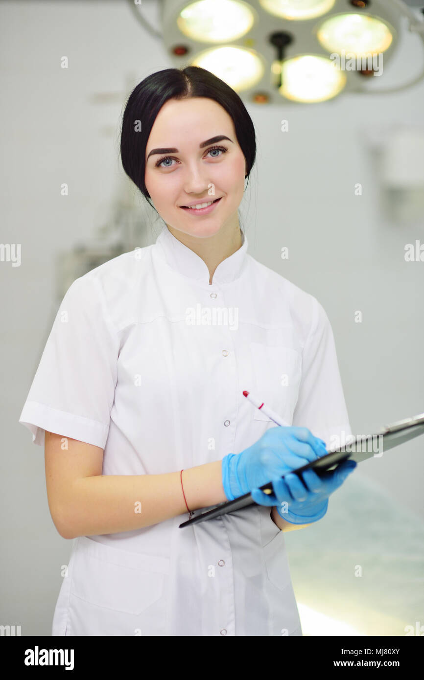 young pretty doctor girl in white medical dressing gown with