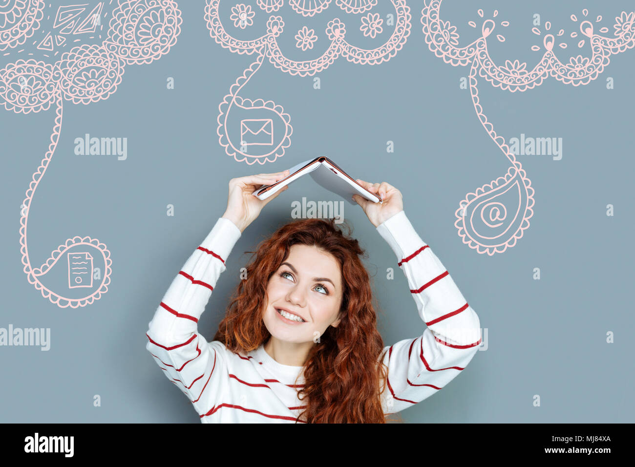 Positive student smiling while putting a book over her head Stock Photo ...