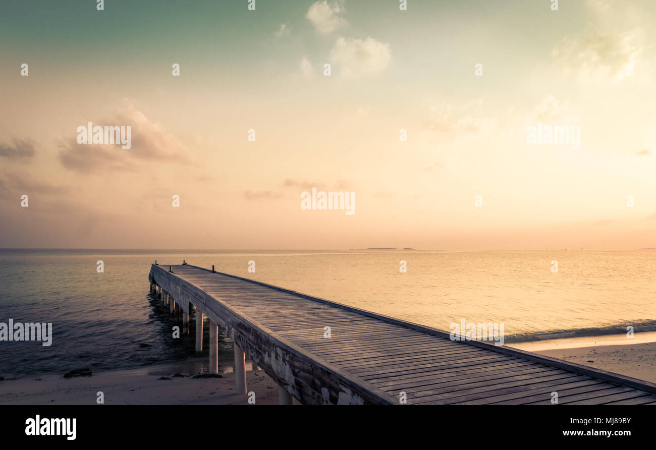 Wooden jetty and amazing sunrise over Indian ocean in Maldives Stock ...