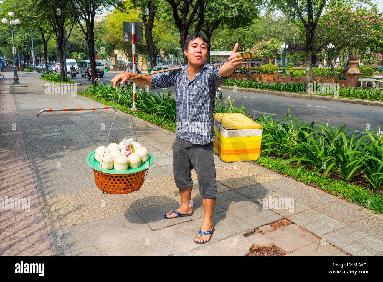 A male Vietnamese street hawker carrying a shoulder pole and selling fresh  coconuts in Ho Chi Minh City, Vietnam Stock Photo - Alamy