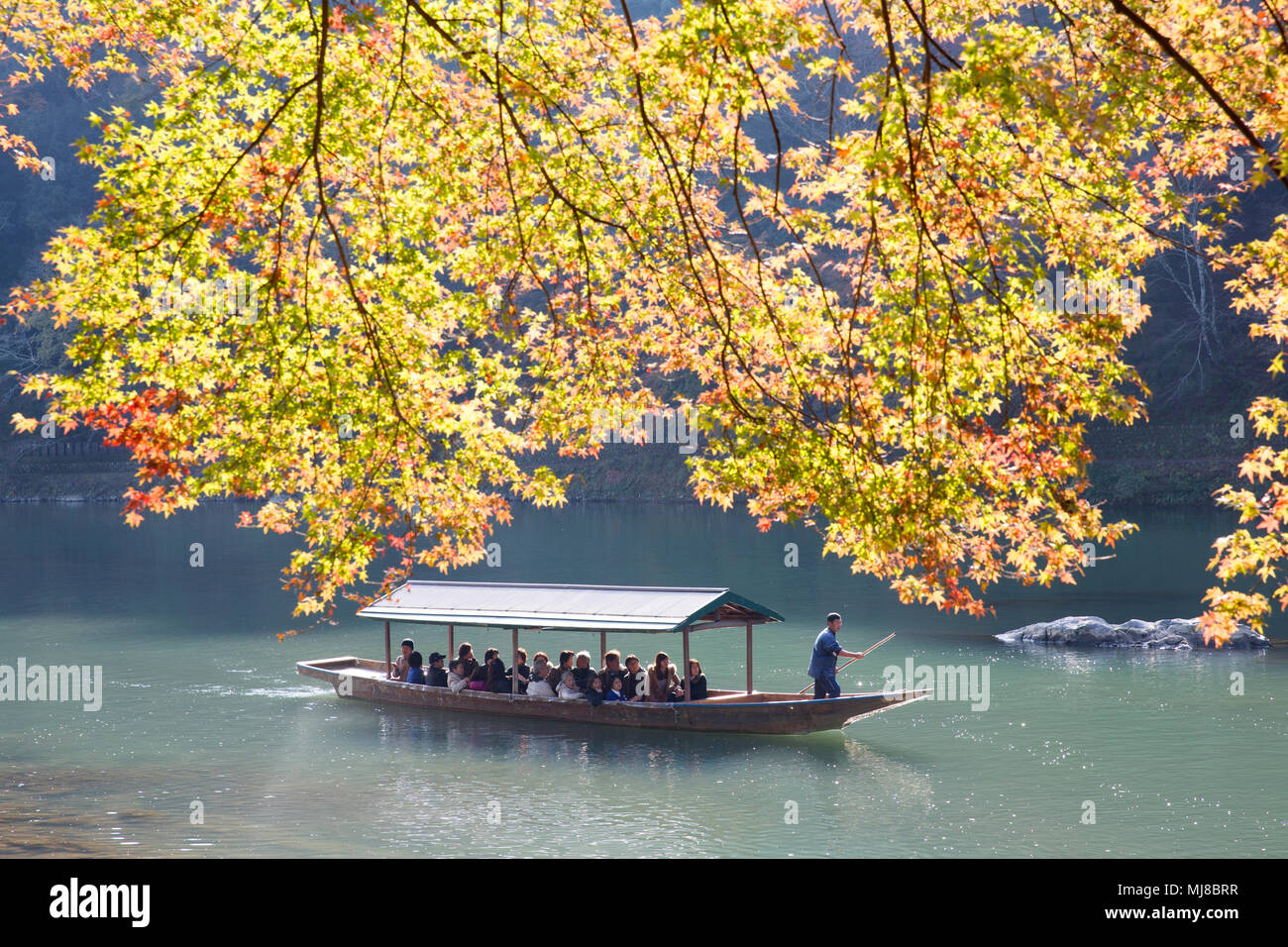 High angle view of group of people on traditional punt on a river in autumn. Stock Photo