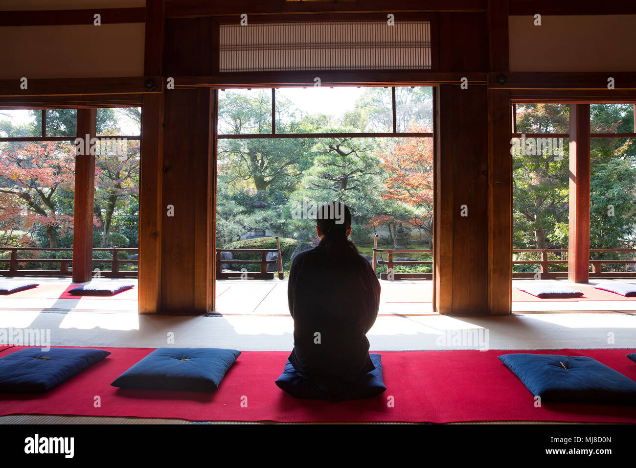 Rear View Of Man Sitting On Blue Cushion On Floor In Traditional