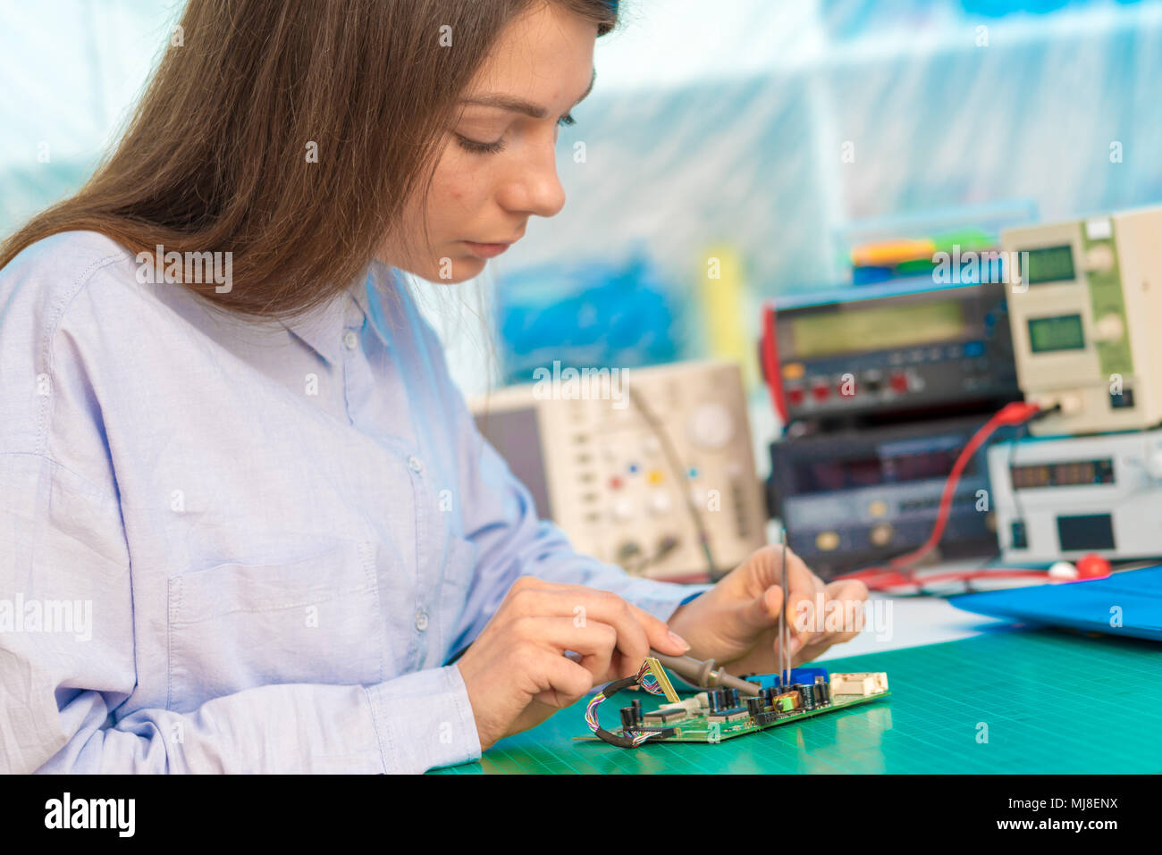Female student in electronics class uses a Measuring device Stock Photo ...
