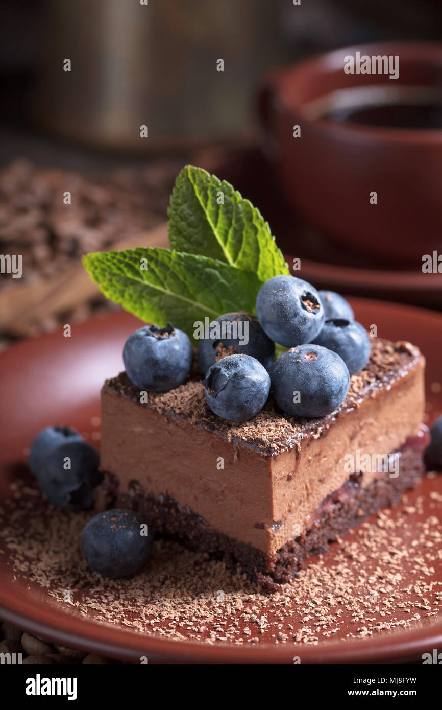 Chocolate cake with blueberries and mint on a brown plate Stock Photo ...