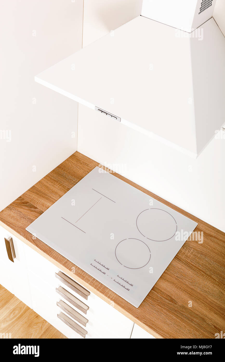Induction cooktop in modern kitchen with hood from above Stock Photo