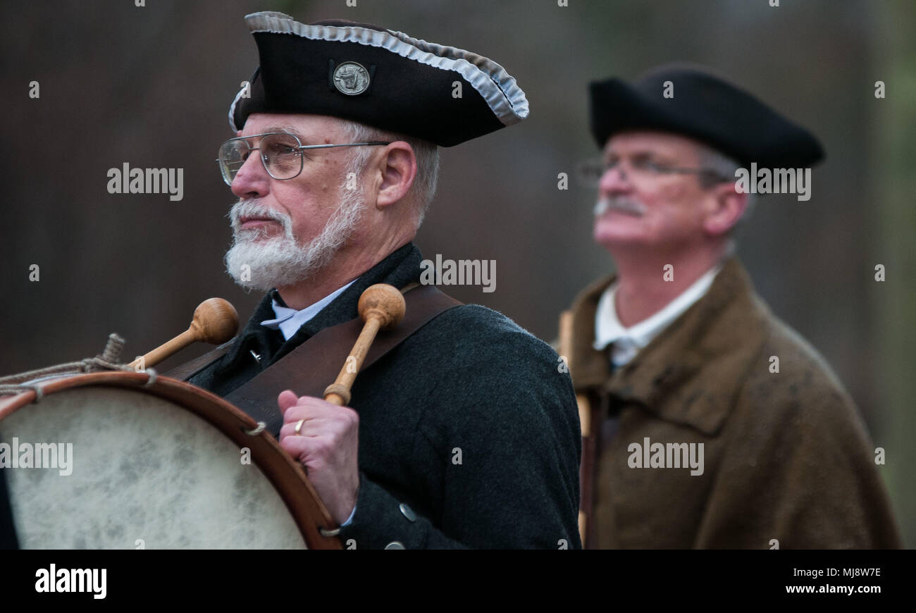 A pair of reenactors beat their drums as they walk along the Old North Bridge at Minuteman National Historic Park in Concord, Massachusetts, April 19, 2018. These reenactors demonstrated citizen soldiers, during the Revolutionary War, in the Shot Heard Around the World that changed America forever. U.S. Army Reserve Soldiers participating in a best warrior competition near by attended the event to motivate them for the competition. (U.S. Army Reserve photo Pvt. Hunter E. Eastman) (Photo cropped and edited for effect.) Stock Photo