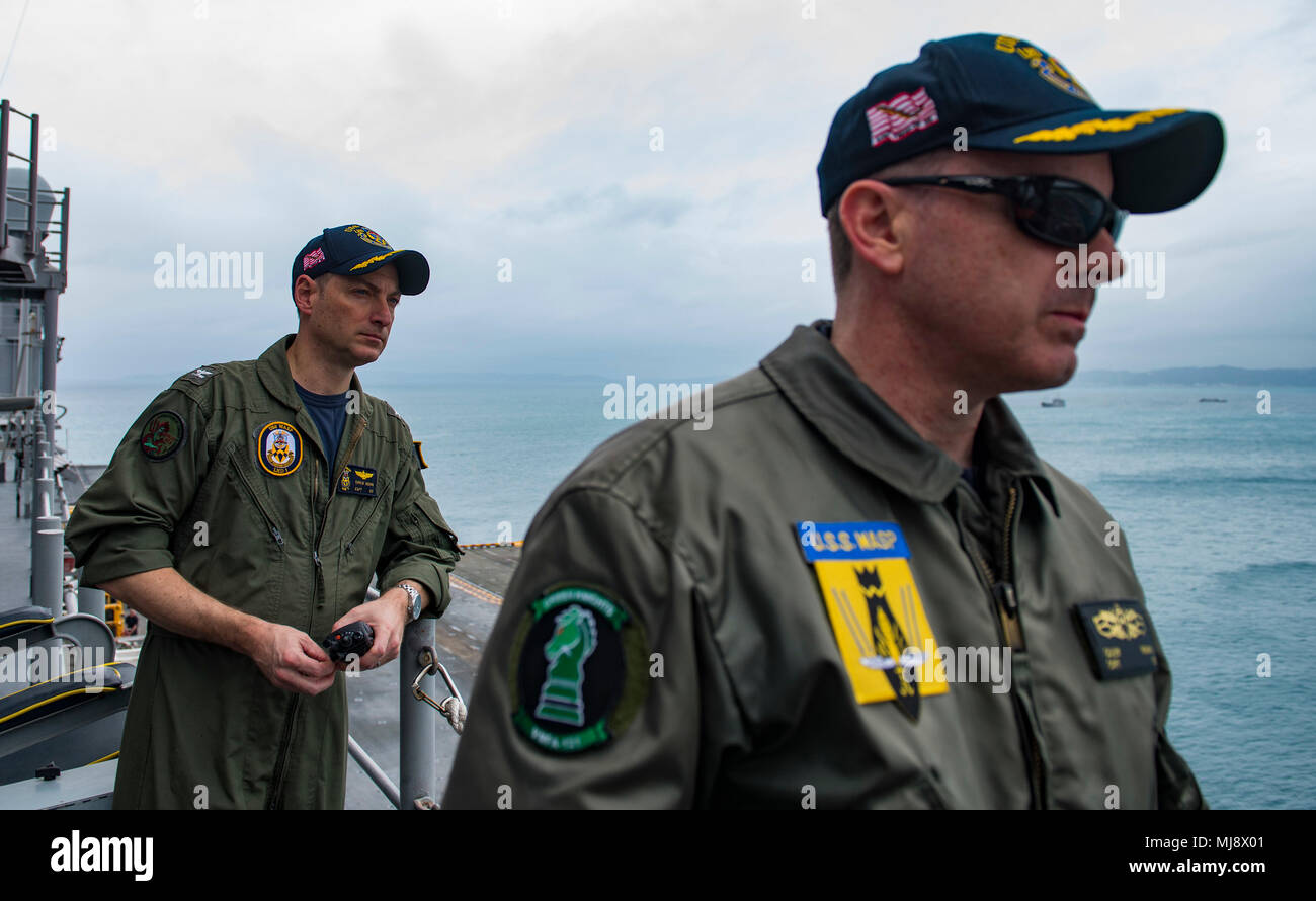 180421-N-BD308-0059 OKINAWA, Japan (April 21, 2018) Capt. Christopher Herr, executive ofﬁcer (left) and Capt. John Howard, commanding ofﬁcer of the amphibious assault ship USS Wasp (LHD 1), observe the ship preparing to moor in Okinawa to disembark the 31st Marine Expeditionary Unit. Wasp, part of the Wasp Expeditionary Strike Group, has been operating with the MEU for nearly two months as part of a routine patrol in the Indo-Paciﬁc. (U.S. Navy photo by Mass Communication Specialist 3rd Class Levingston Lewis/Released) Stock Photo