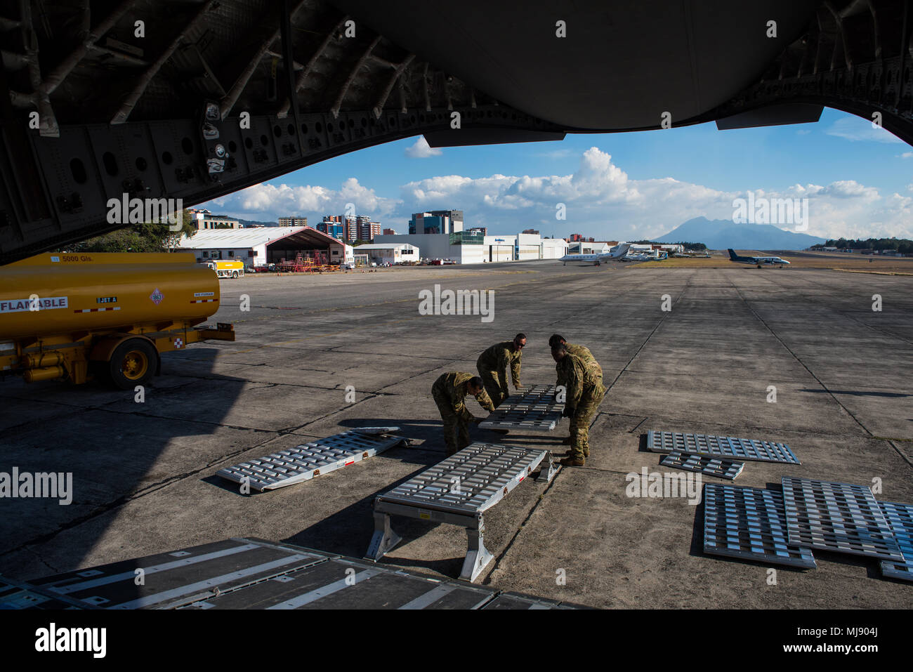 U.S. Airmen with the 21st Airlift Squadron put together a ramp in order to deliver Denton Program emergency response vehicles at La Aurora International Airport, Guatemala City, Guatemala, April 20, 2018. The Denton Program is a Department of Defense transportation program that moves humanitarian cargo, donated by U.S. based Non-Governmental Organizations to developing nations to ease human suffering. The emergency vehicles were donated by the Mission of Love Foundation, they are the largest user of the Denton Program, having delivered medical, relief and humanitarian supplies to needy communi Stock Photo
