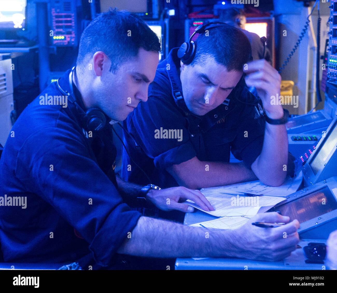 Pacific Ocean (April 20, 2018) Lieutenant Ben Olivas a surface Warfare Tactics Instructor (WTI) assigned to Naval Surface and Mine Warfighting Development Center (SMWDC),  and Lieutenant Chris Bohnker of Naval Operational Support Center (NOSC) Newport, R.I., prepare for an Air Defense exercise during an underway Cruiser-Destroyer (CRUDES) Surface Warfare Advanced Tactical Training (SWATT) exercise aboard USS Stockdale (DDG 106).  Stockdale is one of three CRUDES warships from USS John C. Stennis (CVN 74) Carrier Strike Group (CSG) completing a CRUDES SWATT exercise.  The other ships participat Stock Photo