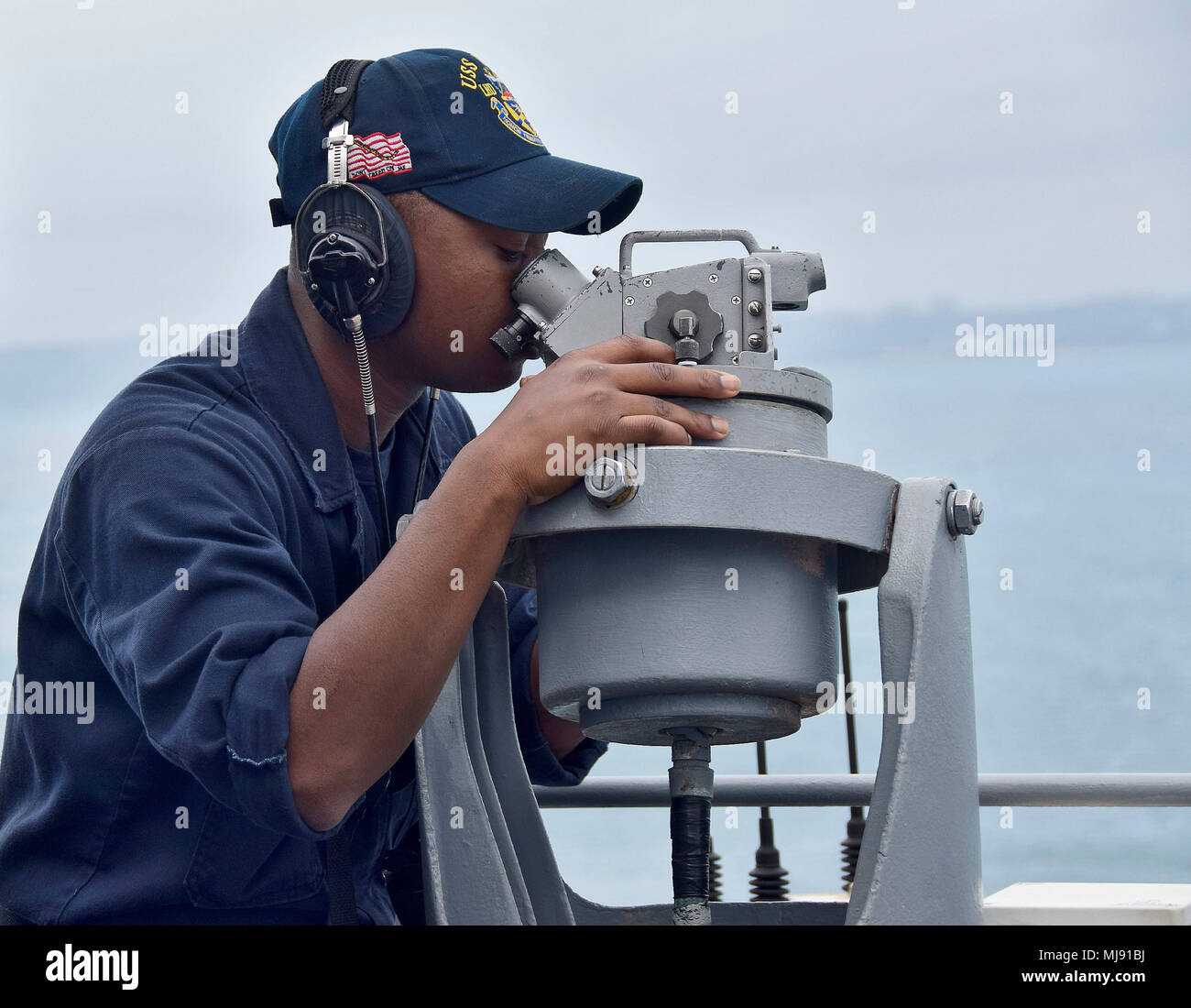 180421-N-RI884-0276 PHILIPPINE SEA (April 21, 2018) Operations Specialist Seaman J'Corey Jackson uses an Alidade, a scientific instrument for measuring angles, aboard the amphibious assault ship USS Wasp (LHD 1) as the ship prepares to moor in Okinawa to disembark the 31st Marine Expeditionary Unit. Wasp, part of the Wasp Expeditionary Strike Group, has been operating with the MEU for nearly two months as part of a routine patrol in the Indo-Pacific. (U.S. Navy photo by Mass Communication Specialist 1st Class Daniel Barker/Released) Stock Photo