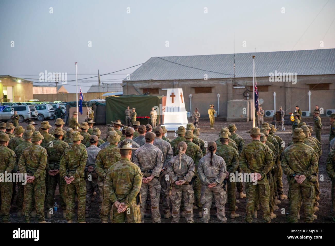 Australian and New Zealand service members stand in a formation during the  dawn service for Anzac