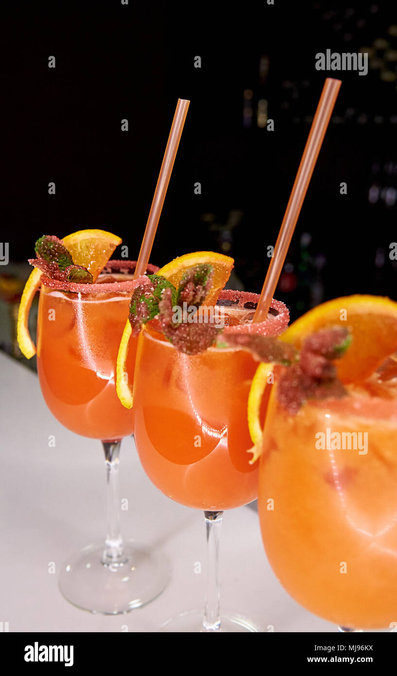 Orange cold cocktail decorated with sugar crumb, orange slice and mint ...