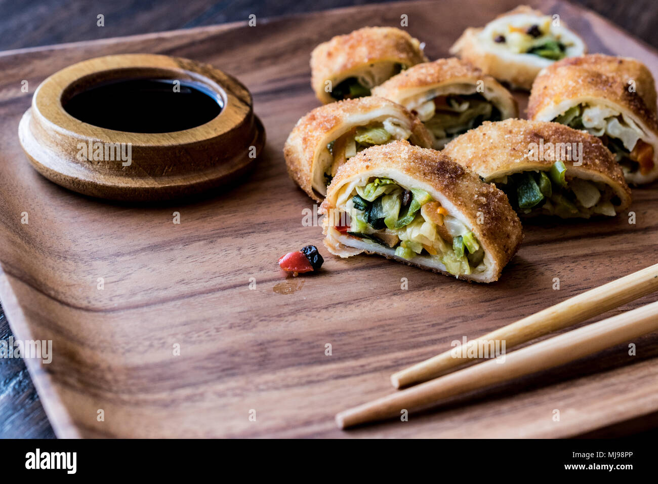 Chinese Vegetable Egg Rolls / Borek with soy (soya) sauce and chopsticks in wooden plate Stock