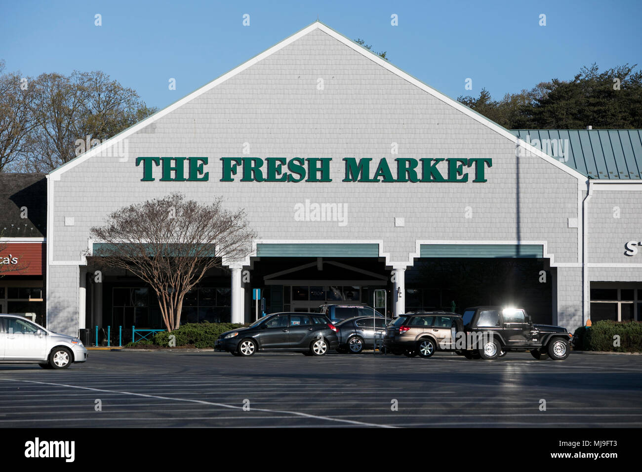 A logo sign outside of a The Fresh Market retail grocery store in