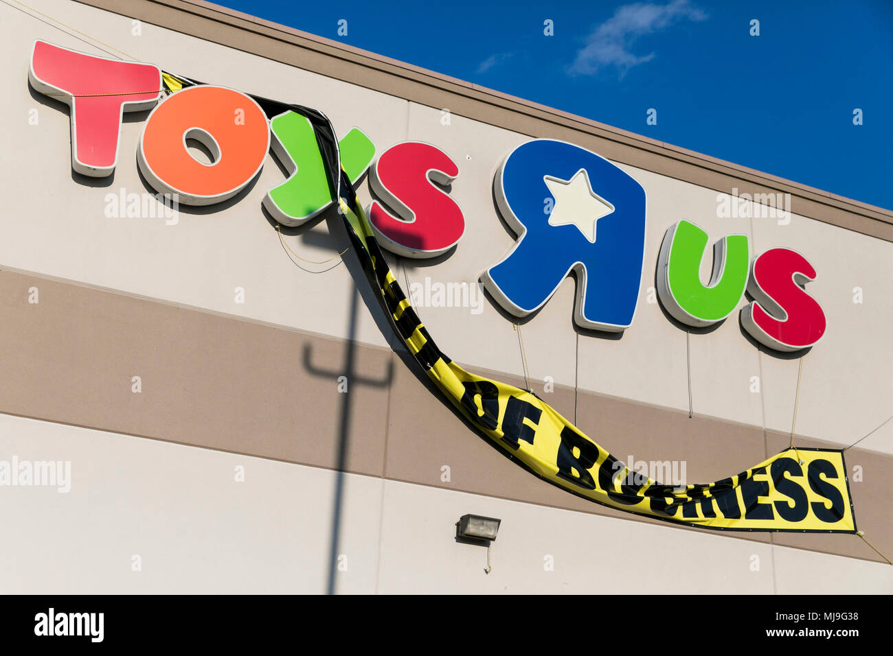 A logo sign outside of a Toys 'R' Us retail store in Glen Burnie, Maryland with 'Going Out Of Business' signage on April 5, 2018. Stock Photo