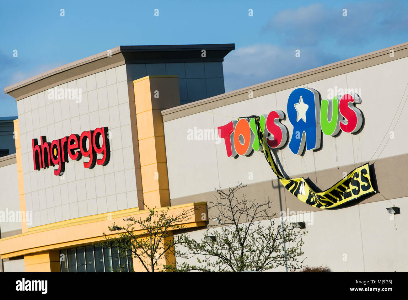 A logo sign outside of a Toys 'R' Us retail store in Glen Burnie, Maryland with 'Going Out Of Business' signage next door to a shuttered store of the  Stock Photo
