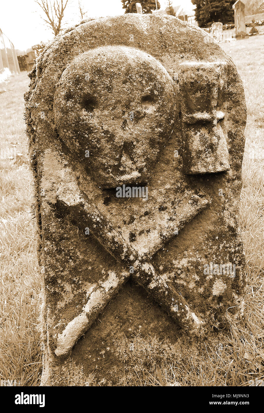 Ancient skull and crossbow symbolism on gravestones in a Dumfries and Galloway, Scotland, country graveyard. (Memento Mori)mortality Stock Photo