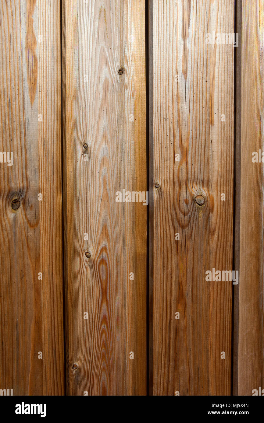 background image of timber planks used in buildings with a planed finish and golden wood stain showing wood grain patterns Stock Photo