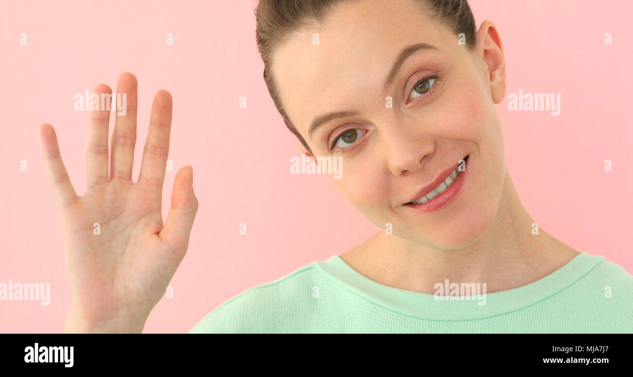 Woman saying hi, waving her hand Positive girl Stock Photo