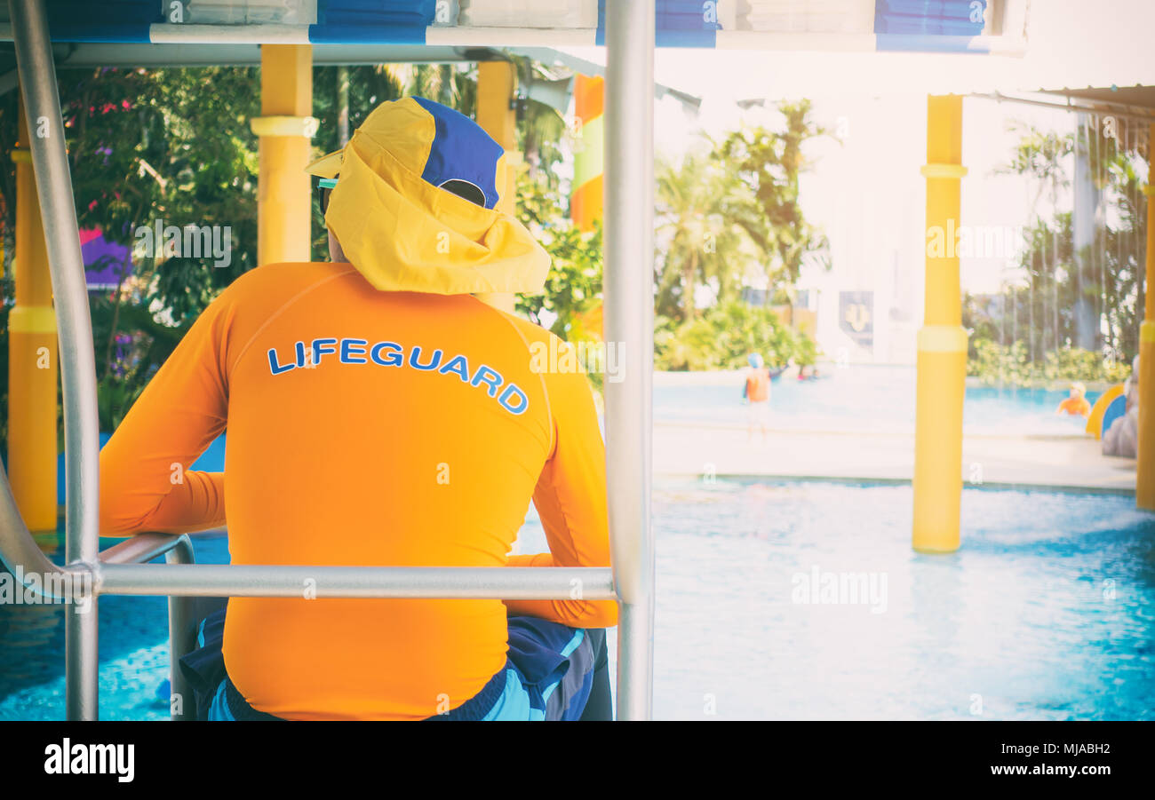 Life gaurd stting on a twoer in swimming pool Stock Photo