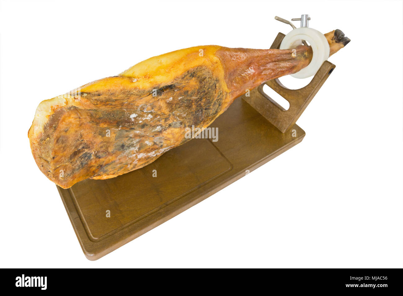 Edge view of whole serrano ham leg over wood, white background Stock