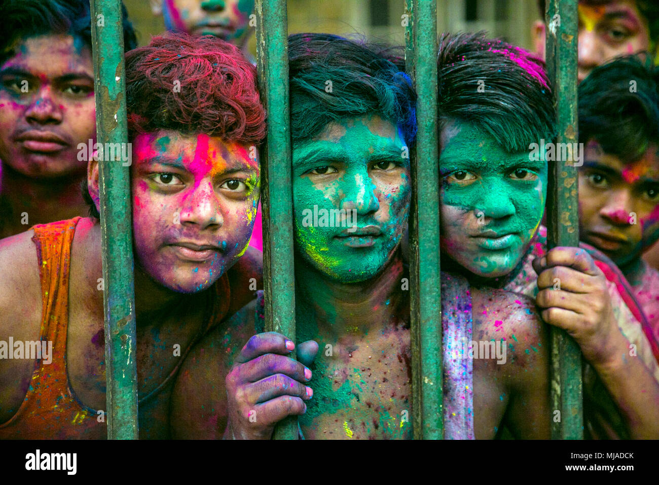 Boys Looking Through Fence, Holi Festival, Mumbai, India Stock Photo