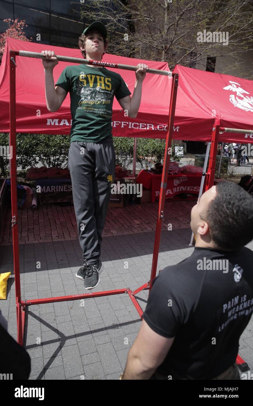 PHILADELPHIA – 16-year-old Jeffrey Roach, a student athlete for Seneca Valley High School in Germantown, Maryland, participates in a Marine Corps pull-up challenge during the Penn Relays at Franklin Field at the University of Pennsylvania campus in Philadelphia, April 26, 2018. Marines partnered with and attended the 124th Penn Relays to foster positive relationships with student athletes and coaches and to educate the track and field community on opportunities within the Marine Corps. (U.S. Marine Corps photo by LCpl. Naomi Marcom) Stock Photo