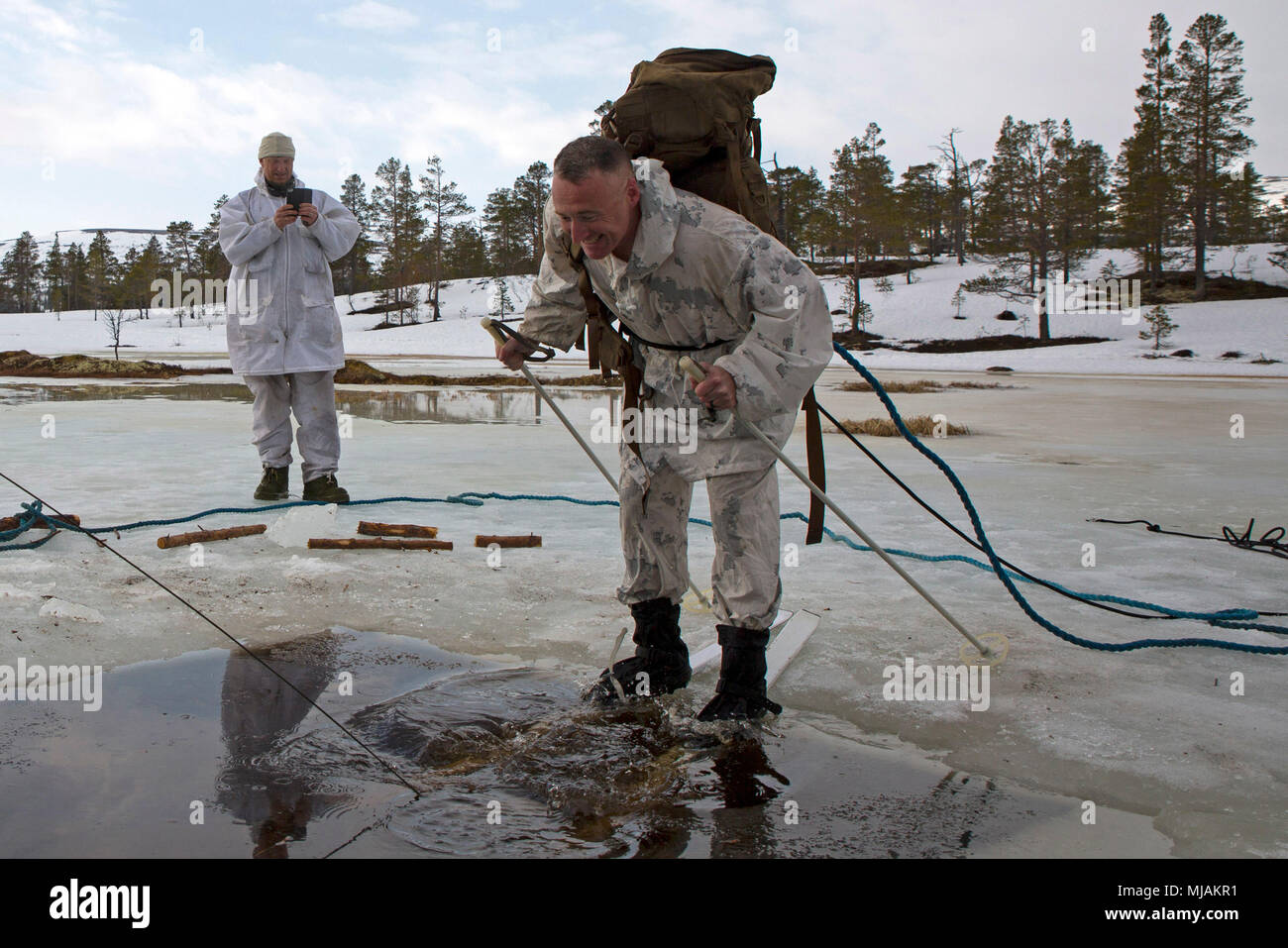 Black Sea Rotational Force and Marine Rotational Force-Europe 18.1 Commanding Officer Lt. Col. G. P. Gordon prepares to be the first individual from his unit to complete the polar plunge during a winter warfare training exercise at Haltdalen Training Center, Norway, April 20, 2018. More than 70 Marines and Sailors spent three weeks in the Norwegian wilderness learning cold weather survival techniques, which were taught by Norwegian Soldiers with Home Guard 12. Marines and Sailors who participated in the polar plunge learned how to properly retain their gear and escape after falling through the Stock Photo