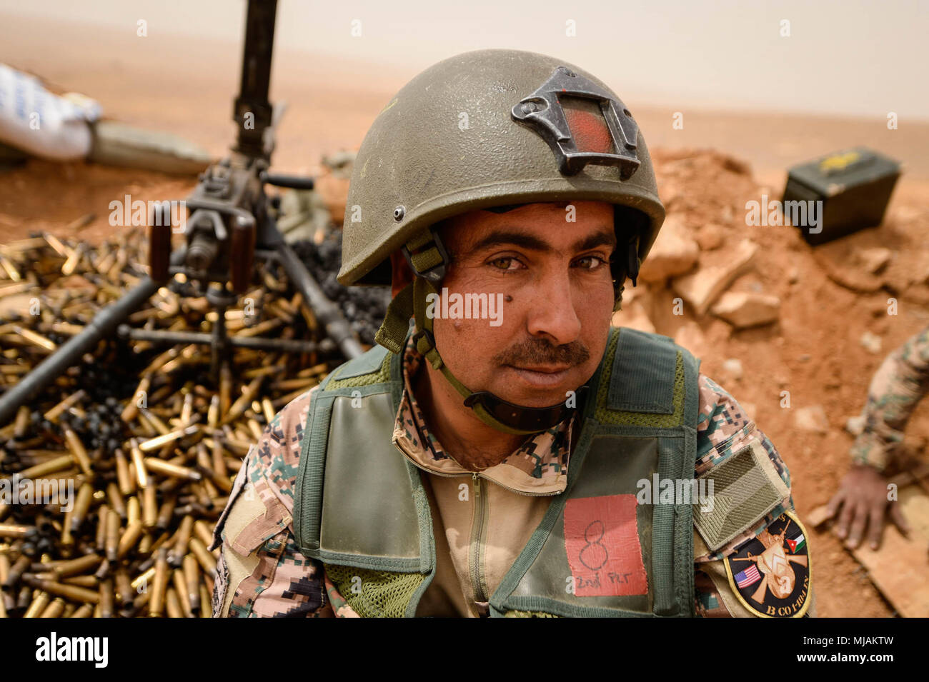 A Jordanian Armed Forces Soldiers in Border Security sits next to a .50  caliber machine gun after firing it during a live fire exercise with  Soldiers of the 1st Battalion, 184th Infantry