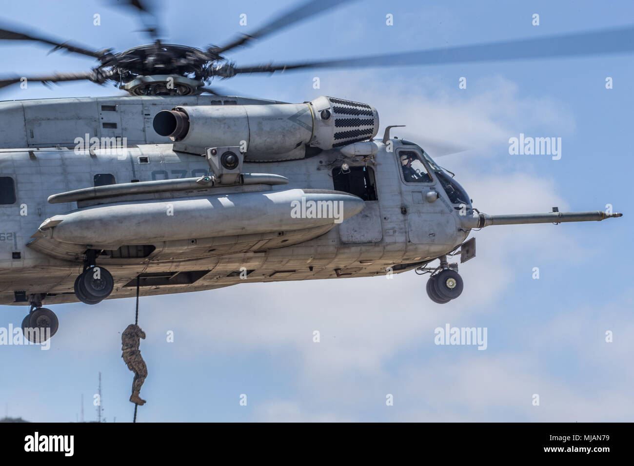 A U.S. Marine rappels from a CH-53E Super Stallion during a fast rope ...