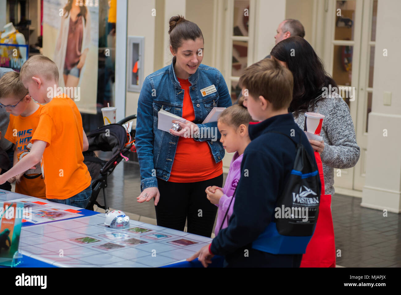 180428-N-SH284-0044 SILVERDALE, Wash., (April 28, 2018) Valerie Johnson, education specialist for the U.S. Naval Undersea Museum, engages with children during the 5th Annual West Sound STEM Showcase at the Kitsap Mall. The showcase presents science, technology, engineering and math principles at a fun, interactive event hosted by dozens of area organizations showcasing hands-on activities to engage youth of all ages. Hits have included a catapult challenge, underwater vehicle exploration, robotics, rocket launches, bridge building, field medicine, egg drops, animals, circuitry, X-ray technolog Stock Photo