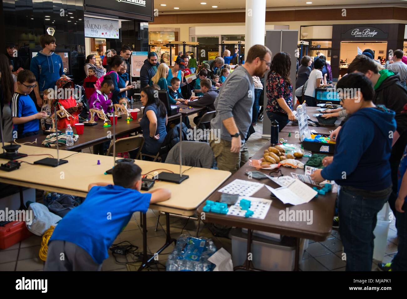 180428-N-SH284-0096 SILVERDALE, Wash., (April 28, 2018) Shipyard workers for the Puget Sound Naval Shipyard and Intermediate Maintenance Facility engage with children during the 5th Annual West Sound STEM Showcase at the Kitsap Mall. The showcase presents science, technology, engineering and math principles at a fun, interactive event hosted by dozens of area organizations showcasing hands-on activities to engage youth of all ages. Hits have included a catapult challenge, underwater vehicle exploration, robotics, rocket launches, bridge building, field medicine, egg drops, animals, circuitry,  Stock Photo