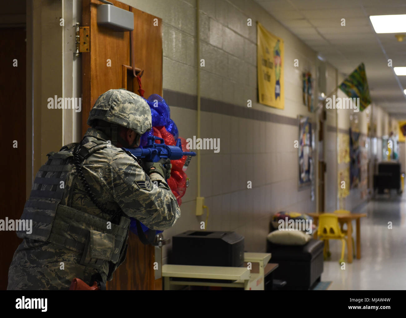 Senior Airman Thomas Cruise, 82nd Security Forces Squadron patrolman, provides overwatch as his partner clears the room during an active-shooter drill at the elementary school on Sheppard Air Force Base, Texas, April 20, 2018. During a sweep, the Security Forces member's jobs were to search for and neutralize the target. They are trained to move toward the sound of gunfire, but if they do not hear anything, they will search each room for the suspect. (U.S. Air Force photo by Airman 1st Class Pedro Tenorio) Stock Photo