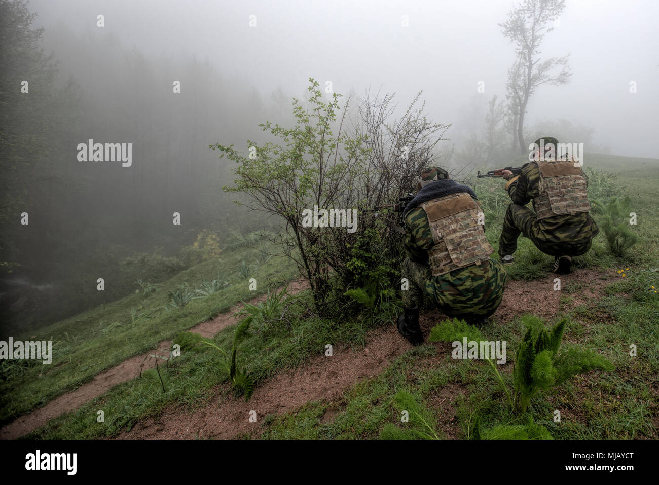 A Tajik sniper and his spotter look through the fog during a simulated ambush at a mountain training camp outside of Dushanbe, Tajikistan, April 19, 2018. This information exchange was part of a larger military-to-military engagement taking place with the Tajikistan Peacekeeping Battalion of the Mobile Forces and the 648th Military Engagement Team, Georgia Army National Guard, involving border security tactics and techniques. Stock Photo