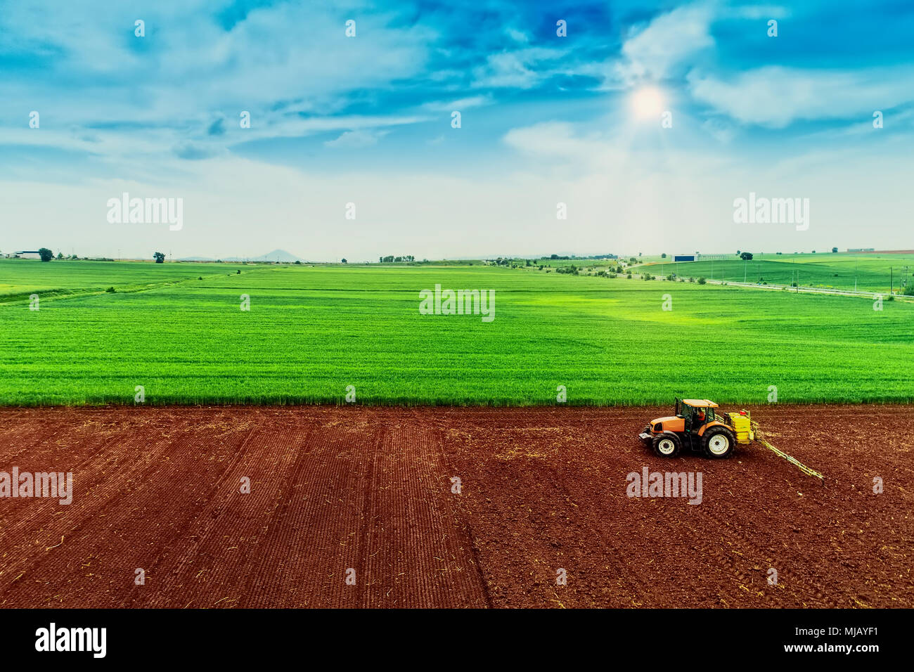 Aerial shot of  Farmer with a tractor on the agricultural field sowing. tractors working on the agricultural field in spring. Cotton seed Stock Photo