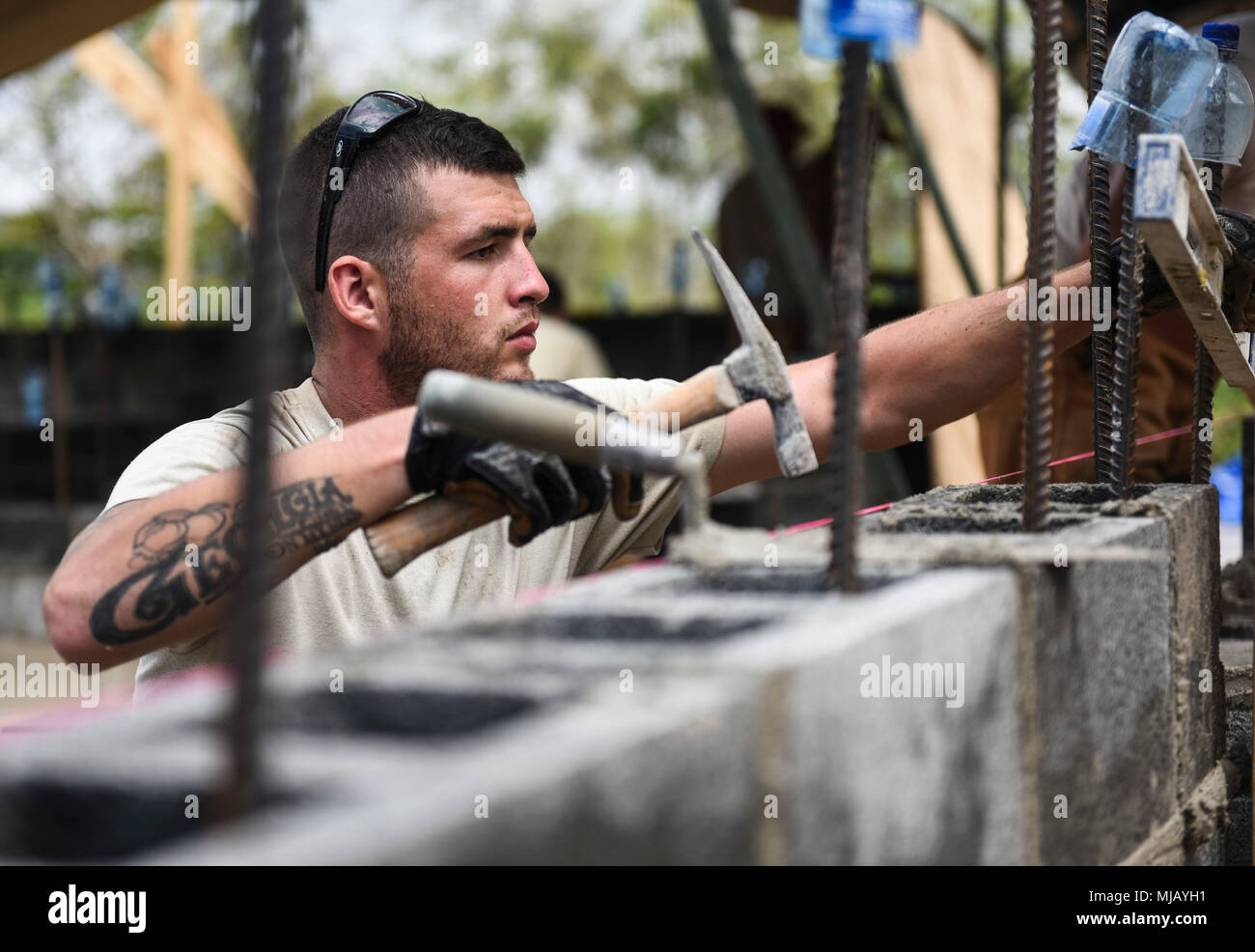 U.S. Air Force Senior Airman Dan Bentz, 346th Air Expeditionary Group Rapid Engineer Deployable Heavy Operational Repair Squadron Engineer member who is deployed from Nellis Air Force Base, Nev., hammers a concrete block into place April 27, 2018 at a construction site in Meteti, Panama. Bentz is participating in Exercise New Horizons 2018, which will assist communities throughout Panama by providing medical assistance and building facilities such as schools, a youth community center and a women’s health ward. (U.S. Air Force photo by Senior Airman Dustin Mullen/Released) Stock Photo