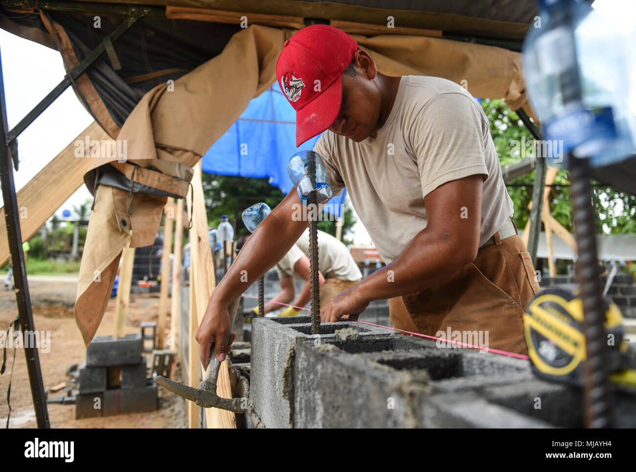 U.S. Air Force Staff Sgt. Jorge Meza, 346th Air Expeditionary Group Rapid Engineer Deployable Heavy Operational Repair Squadron Engineer member who is deployed from Nellis Air Force Base, Nev., ensures a concert block is placed correctly April 27, 2018 at a construction site in Meteti, Panama. Meza is participating in Exercise New Horizons 2018, which is a joint training exercise where U.S. military members conduct training in civil engineer, medical, and support services while benefiting the local community. (U.S. Air Force photo by Senior Airman Dustin Mullen/Released) Stock Photo