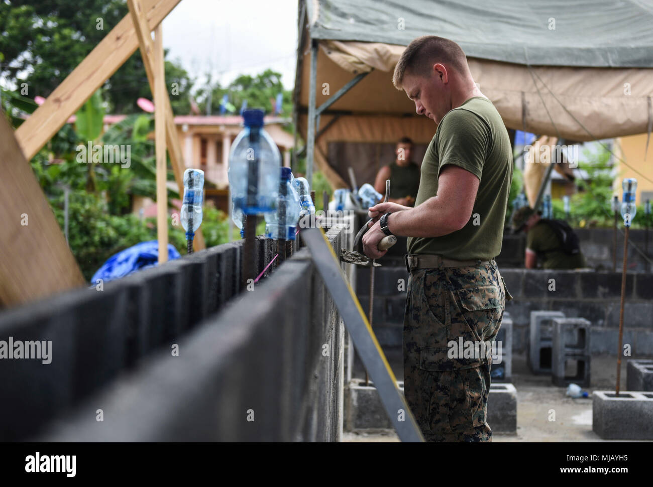 U.S. Marine Corps Reserve Lance Cpl. Darrin Gingerich, 346th Air Expeditionary Group combat engineer who is deployed from Peoria, Ill, uses concrete to fill gaps April 27, 2018 at a construction site in Meteti, Panama. Gingerich is participating in Exercise New Horizons 2018, which will assist communities throughout Panama by providing medical assistance and building facilities such as schools, a youth community center and a women’s health ward. (U.S. Air Force photo by Senior Airman Dustin Mullen/Released) Stock Photo