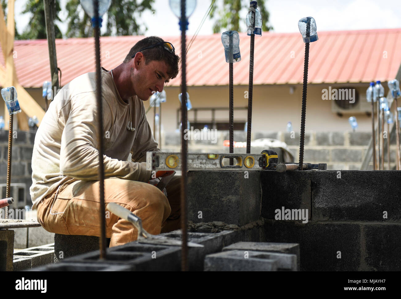 U.S Air Force Tech. Sgt. Carlos Spade, 346th Air Expeditionary Group Rapid Engineer Deployable Heavy Operational Repair Squadron Engineer member who is deployed from Nellis Air Force Base, Nev., ensures a concrete block is level April 27, 2018 at a construction site in Meteti, Panama. Spade is participating in Exercise New Horizons 2018, which will assist communities throughout Panama by providing medical assistance and building facilities such as schools, a youth community center and a women’s health ward. (U.S. Air Force photo by Senior Airman Dustin Mullen/Released) Stock Photo