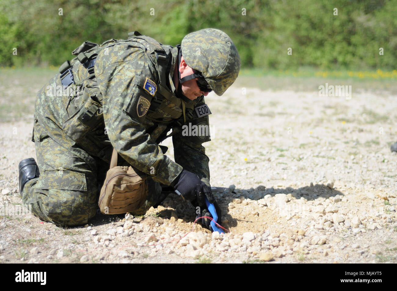 Kosovo Army Staff Sgt. Islam Kadriu, team leader, Explosive Ordnance Disposal Company, Kosovo Civil Protection Regiment, uncovers a mock improvised explosive device on the IED lanes in the Hohenfels Training Area, Hohenfels, Germany, during Combined Resolve X on April 27, 2018. Combined Resolve X includes approximately 3,700 participants from 13 nations at the 7th Army Training Command’s Grafenwoehr and Hohenfels Training Area, April 9 to May 12, 2018. Combined Resolve is a U.S. Army Europe-directed multinational exercise designed to give the Army’s regionally allocated combat brigades to Euro Stock Photo