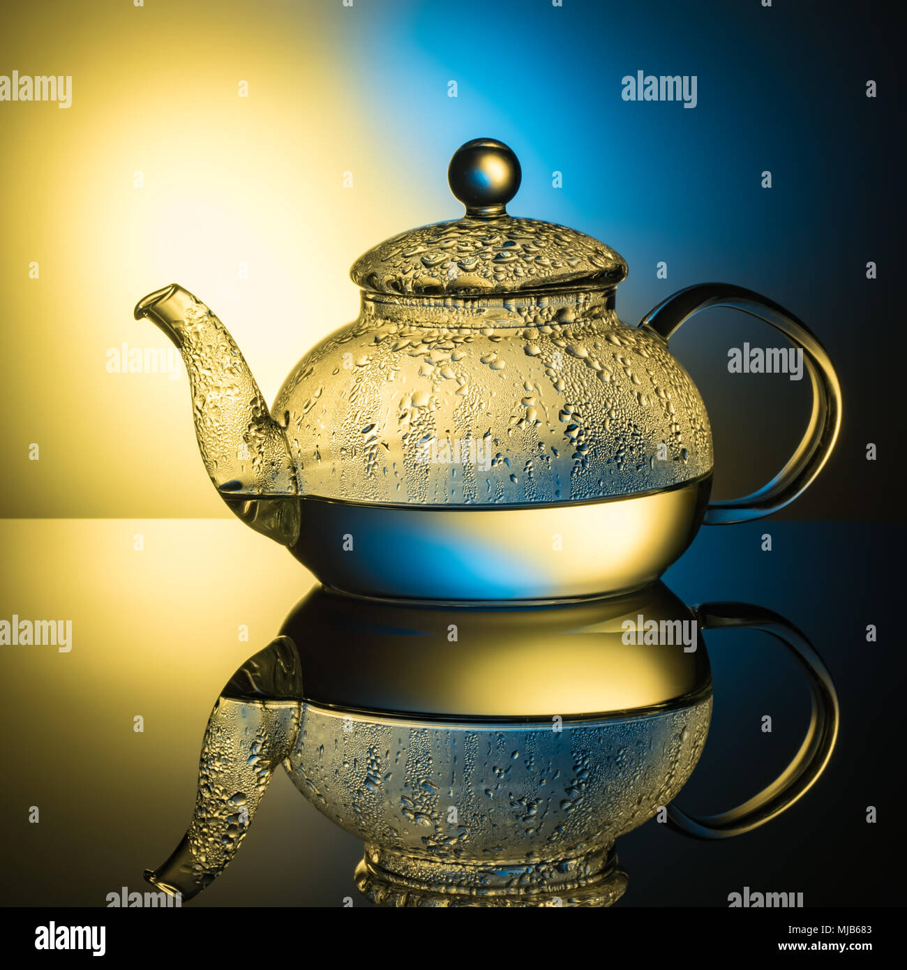 Glass teapot with boiling water and drops of condensation on glass