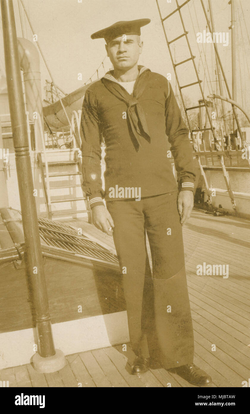 Antique c1922 photograph, a sailor in Coast Guard dress blue aboard an unkown ship. SOURCE: ORIGINAL PHOTOGRAPHIC PRINT. Stock Photo