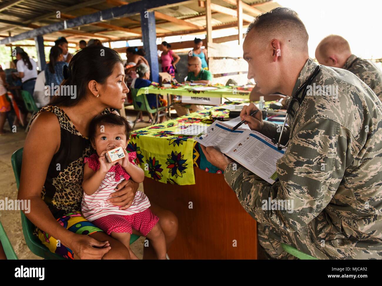 U.S. Air Force Capt. Charles Hutchings, 346th Expeditionary Medical Operations Squadron pediatrician, explains info to a local woman near Meteti, Panama, April 17, 2018. Hutchings was part of an Embedded Health Engagement Team, which gave him a unique learning experience by submerging him into local clinics. The team was participating in Exercise New Horizons 2018, which will assist communities throughout Panama by providing medical assistance and building facilities such as schools, a youth community center and a women’s health ward. (U.S. Air Force photo by Senior Airman Dustin Mullen/Releas Stock Photo